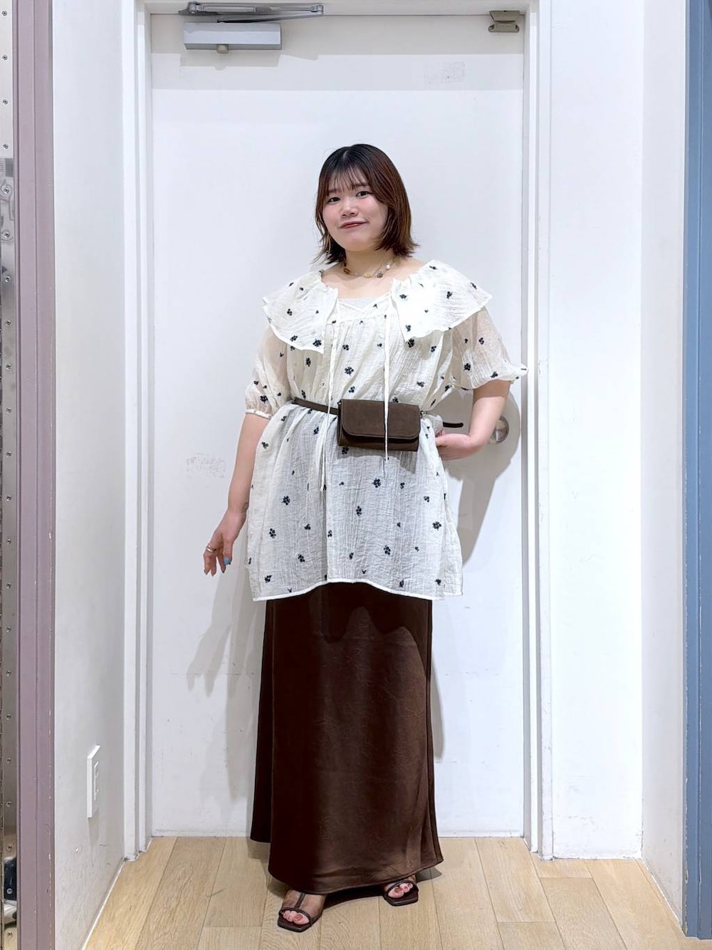 ホワイト系のワンピース、ブラウン系のスカート、シルバー系のタンクトップを着用したレディースの夏コーディネートの1枚目の写真