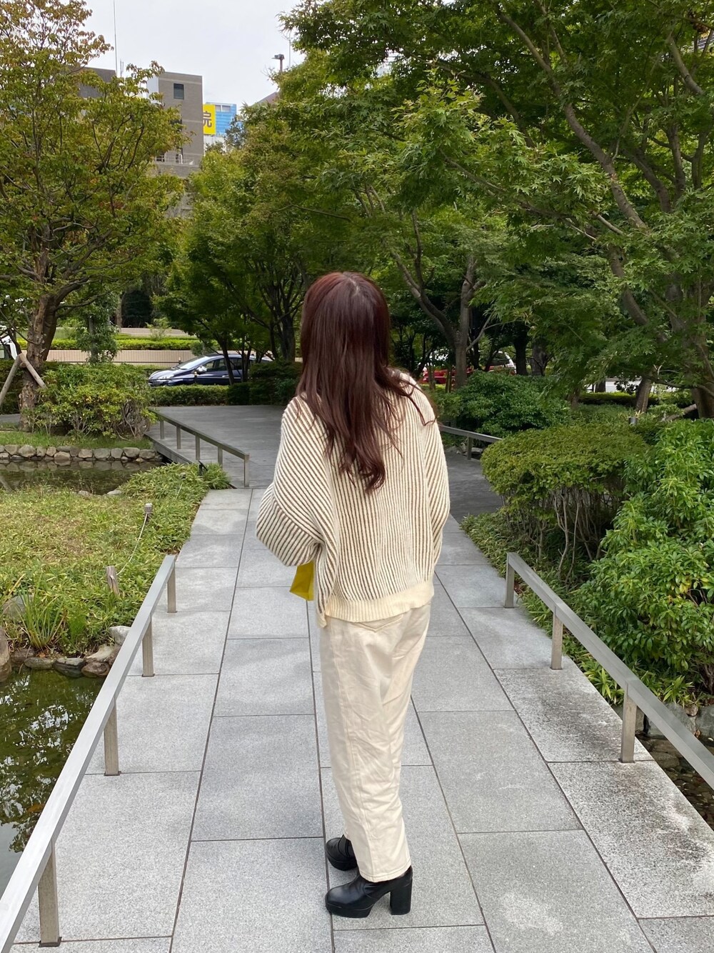 ブラック系のブーツ、ホワイト系のデニムパンツ、ベージュ系のニット/セーターを着用したレディースの冬コーディネートの1枚目の写真