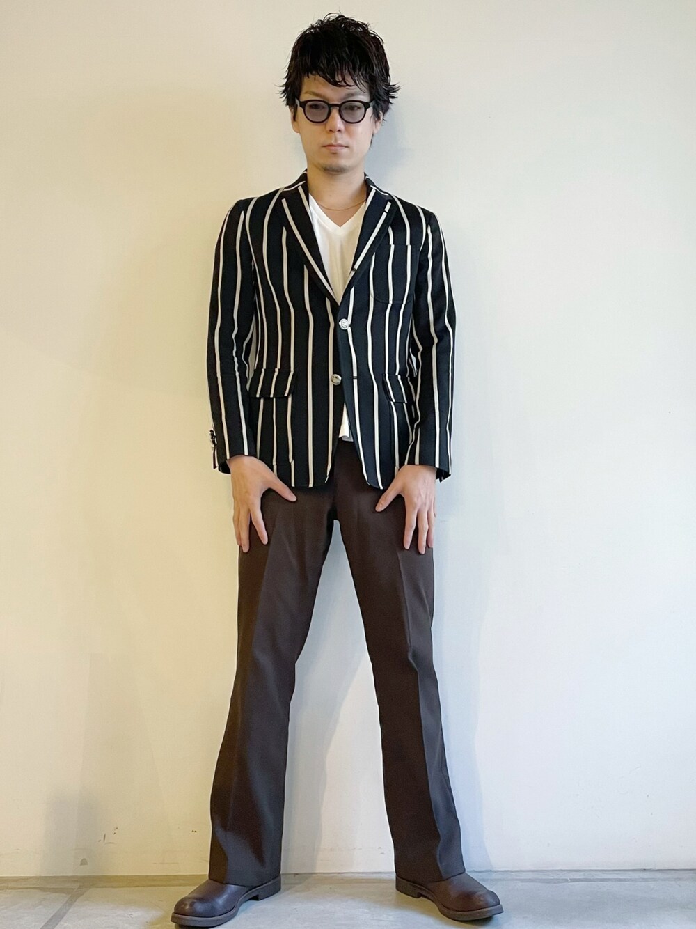 ブラウン系のスラックス、ブラウン系のブーツ、ホワイト系のTシャツ/カットソーを着用したメンズの秋コーディネートの1枚目の写真