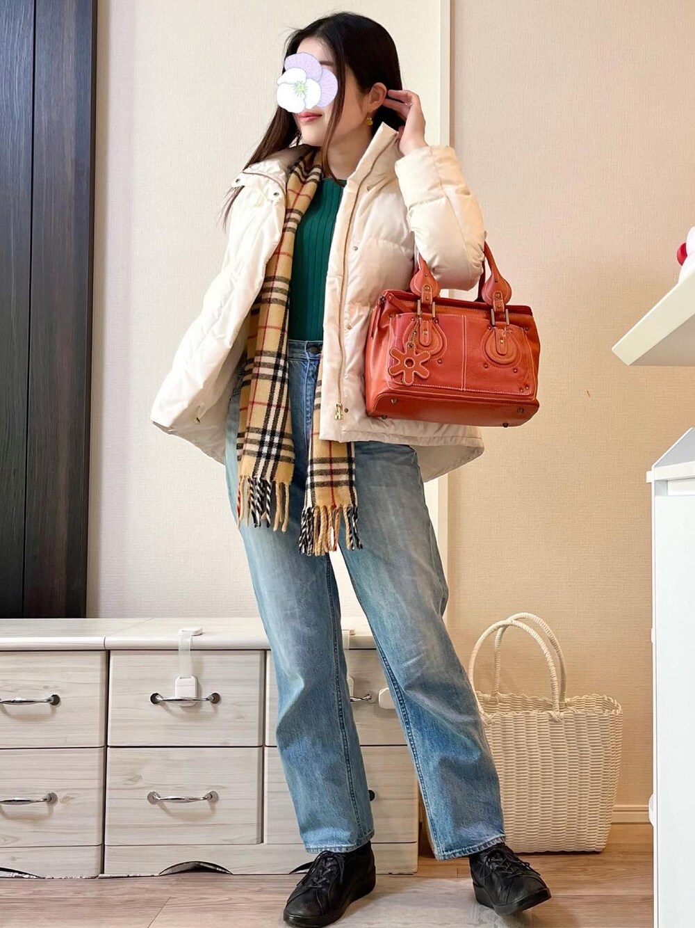 グリーン系のニット/セーター、ブルー系のデニムパンツ、イエロー系のピアス(両耳用)を着用したレディースの冬コーディネートの1枚目の写真