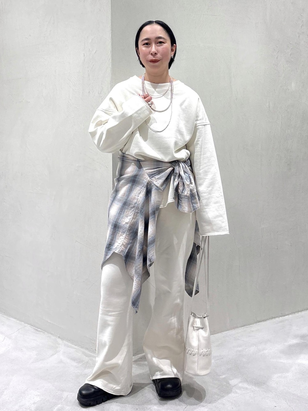 ブラック系のスニーカー、ホワイト系のショルダーバッグ、ブルー系のシャツ/ブラウスを着用したレディースの春コーディネートの1枚目の写真