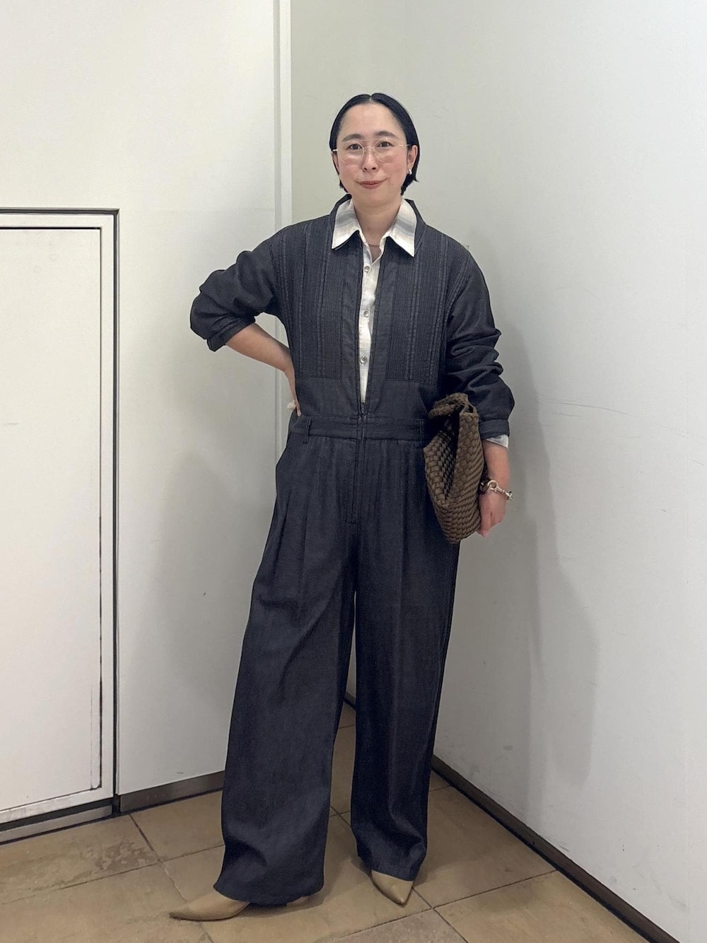 ベージュ系のパンプス、ブルー系のシャツ/ブラウス、イエロー系のトートバッグを着用したレディースの春コーディネートの1枚目の写真