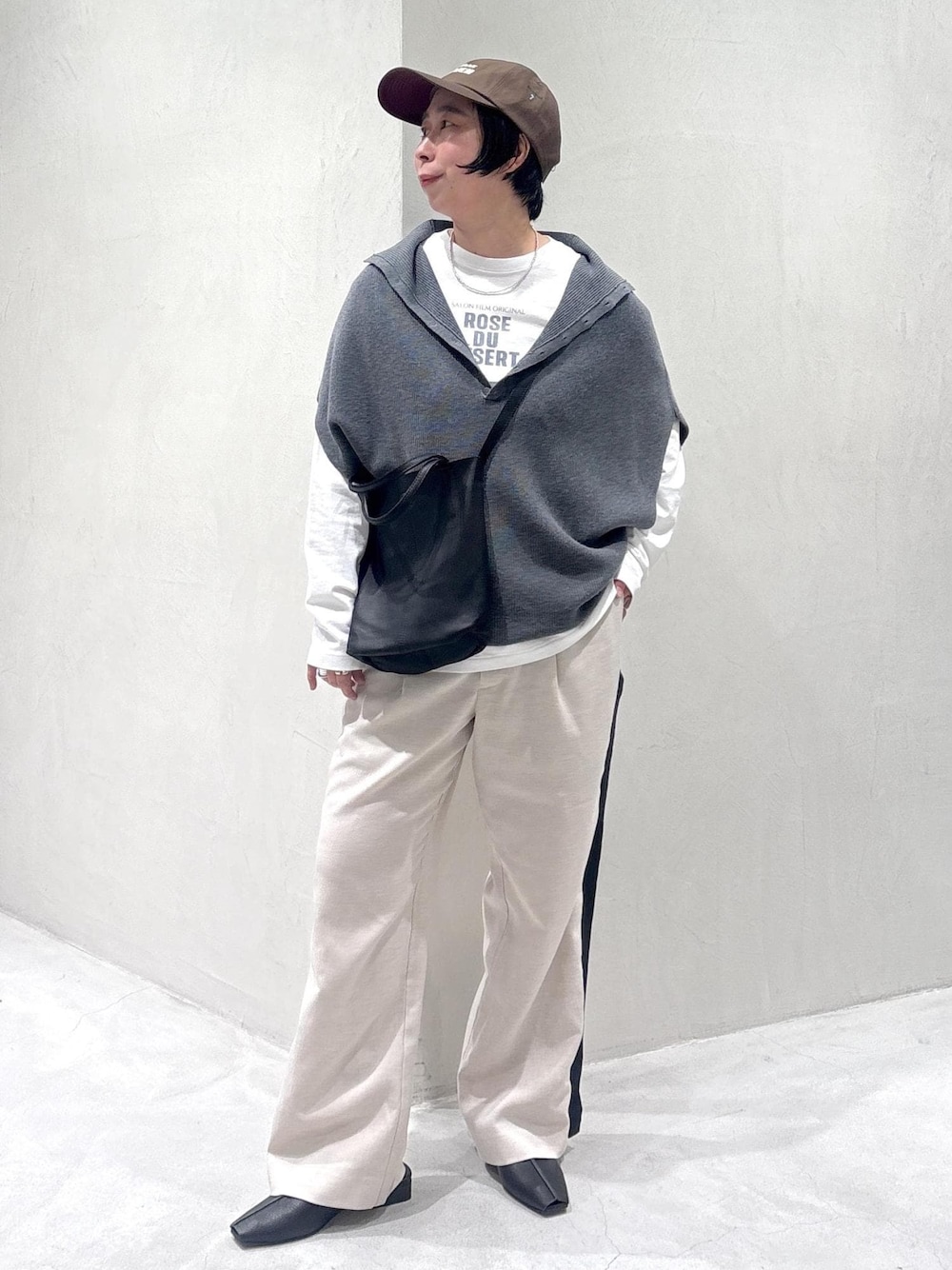 グレー系のニット/セーター、ブラック系のその他シューズ、ホワイト系のTシャツ/カットソーを着用したレディースの冬コーディネートの1枚目の写真