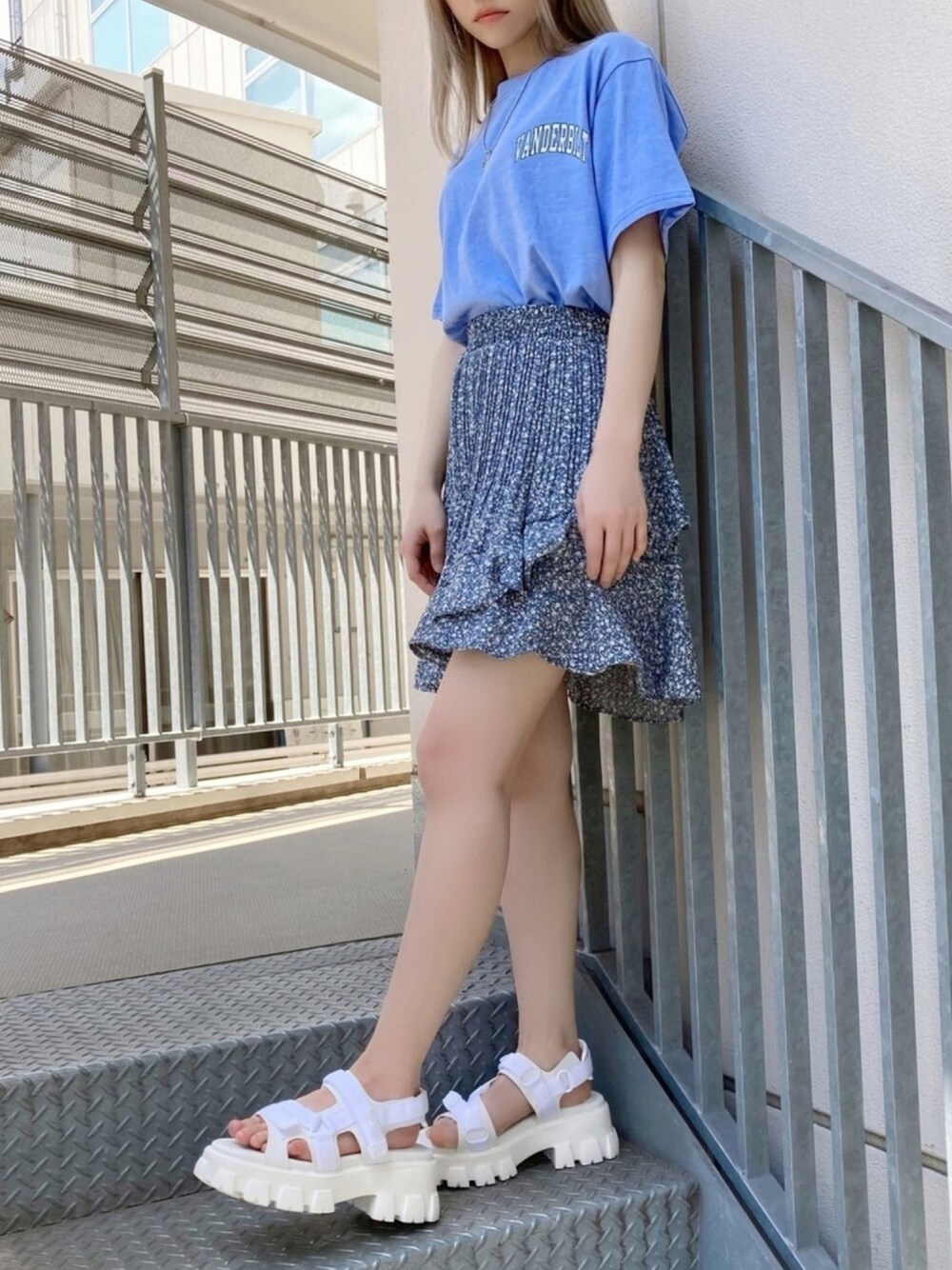 ホワイト系のサンダル、ブルー系のスカート、ブルー系のTシャツ/カットソーを着用したレディースの夏コーディネートの1枚目の写真