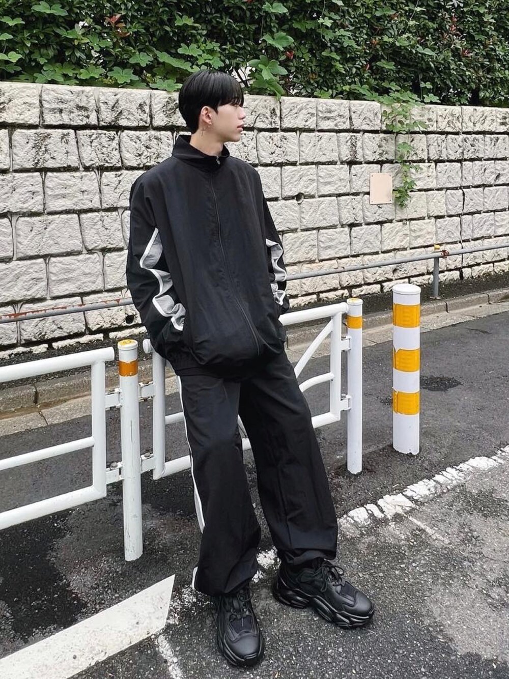 ブラック系のナイロンジャケット、ブラック系のその他パンツ、ブラック系のスニーカーを着用したメンズの冬コーディネートの1枚目の写真
