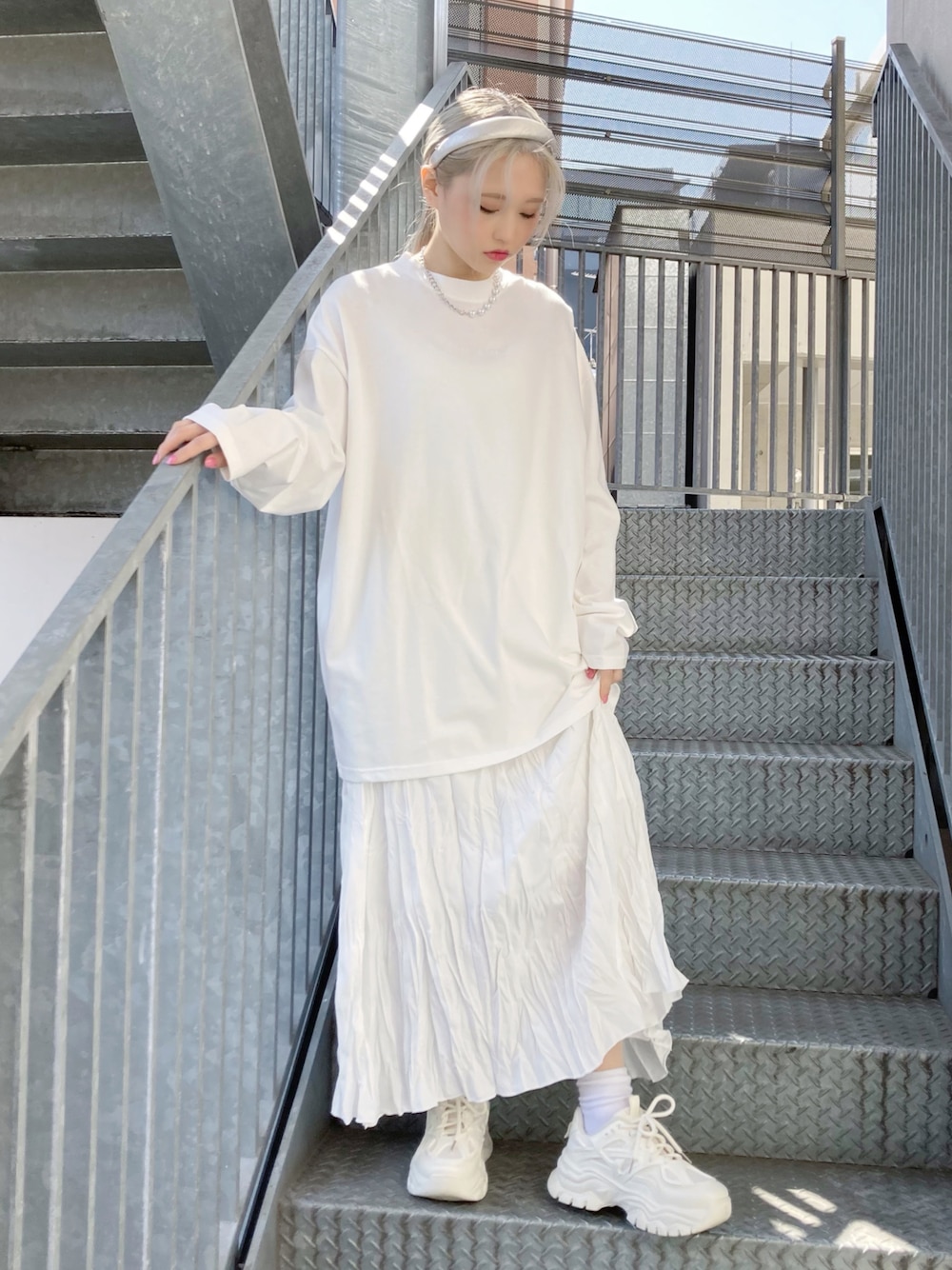 ホワイト系のTシャツ/カットソー、ホワイト系のスカート、ホワイト系のスニーカーを着用したレディースの春コーディネートの1枚目の写真