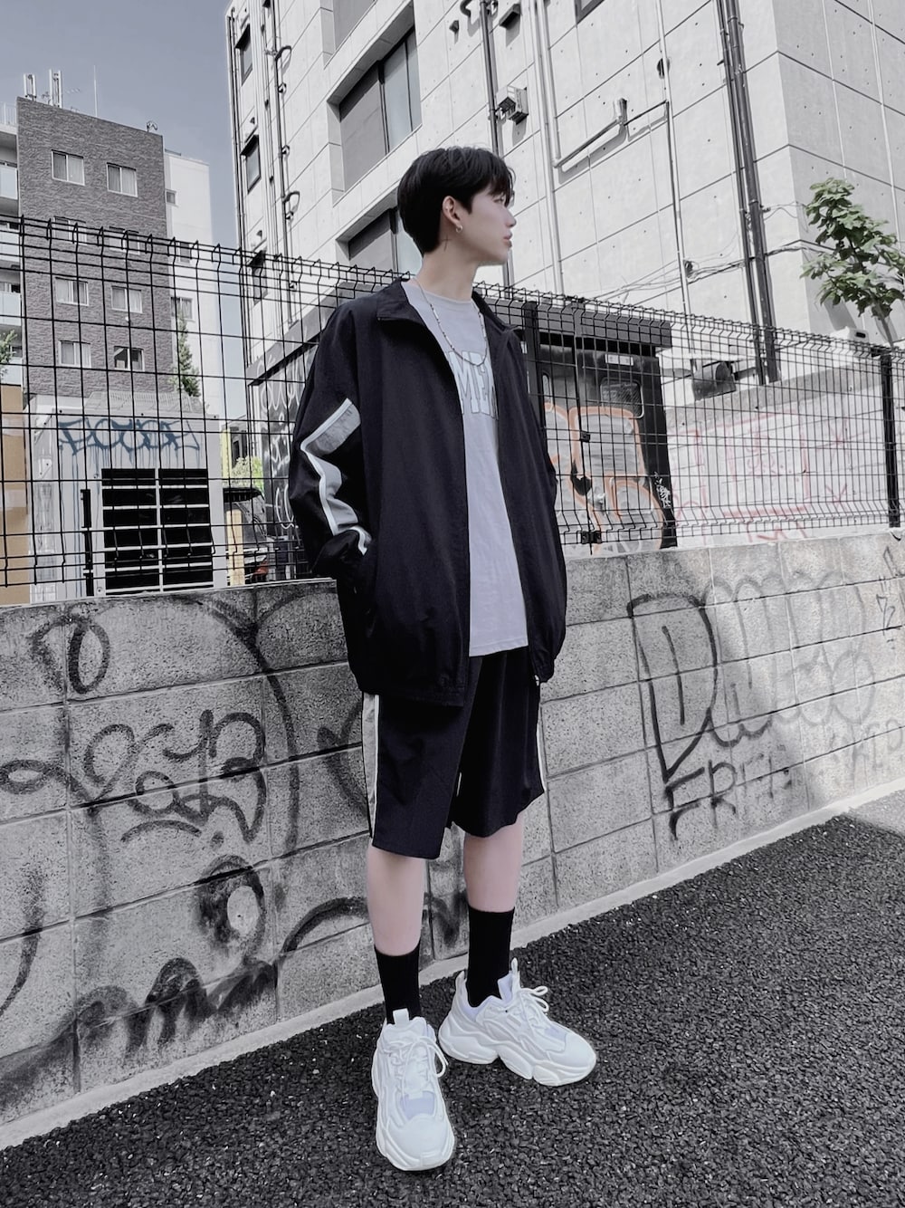 ブラック系のナイロンジャケット、グレー系のTシャツ/カットソー、ブラック系のその他パンツを着用したメンズの春コーディネートの1枚目の写真