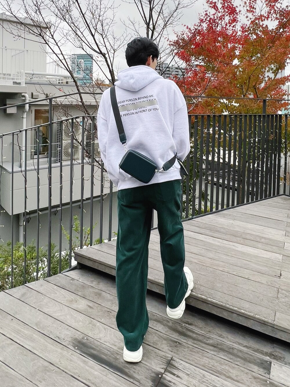 グレー系のパーカー、グリーン系のその他パンツ、ホワイト系のスニーカーを着用したメンズの冬コーディネートの1枚目の写真
