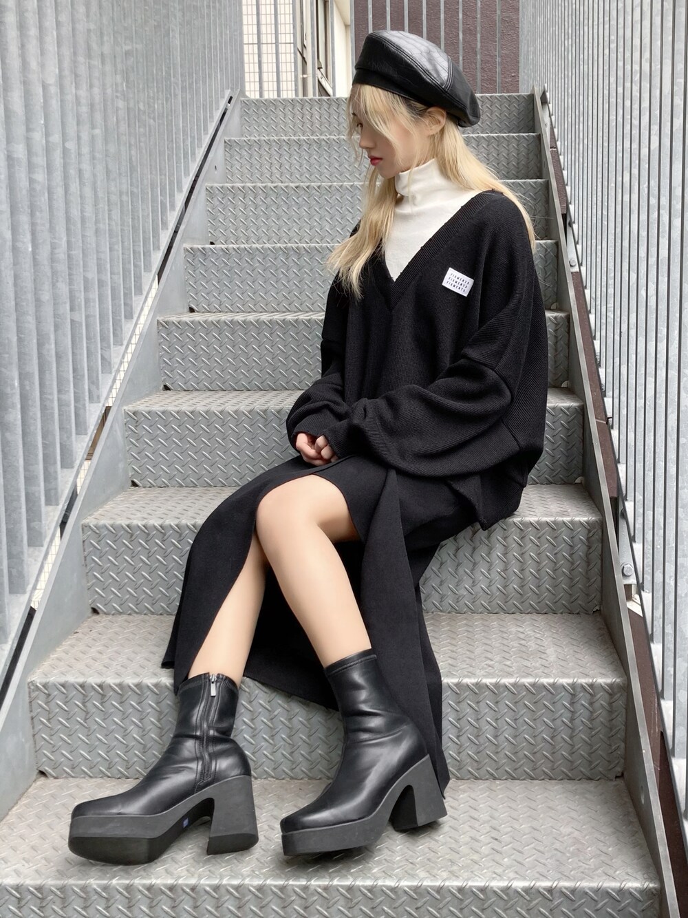 ホワイト系のTシャツ/カットソー、ブラック系のブーツ、ブラック系のニット/セーターを着用したレディースの冬コーディネートの1枚目の写真