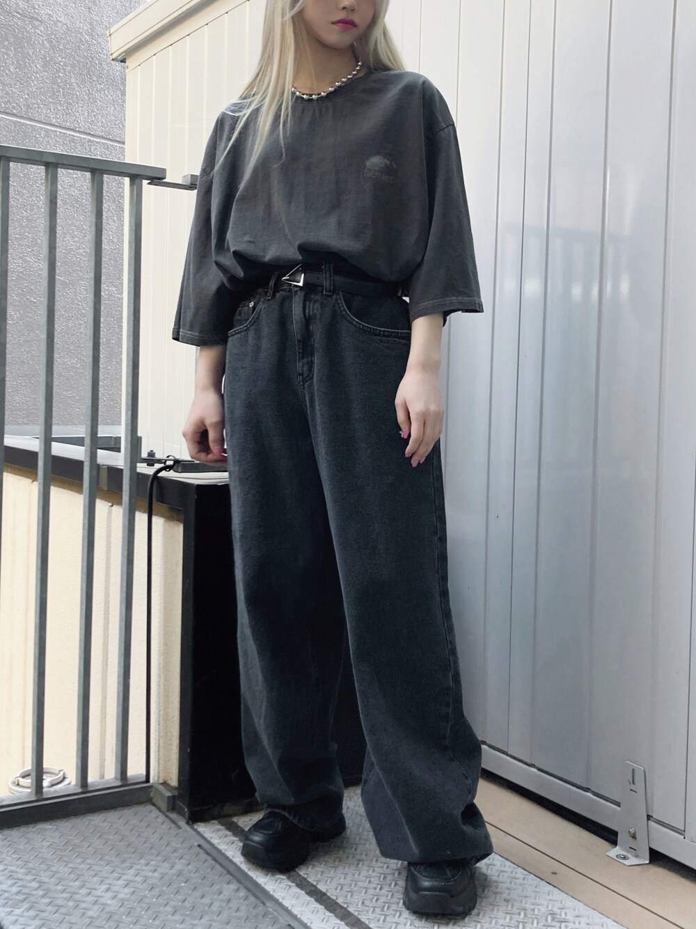 ブラック系のデニムパンツ、ブラック系のスニーカー、ブラック系のTシャツ/カットソーを着用したレディースの春コーディネートの1枚目の写真