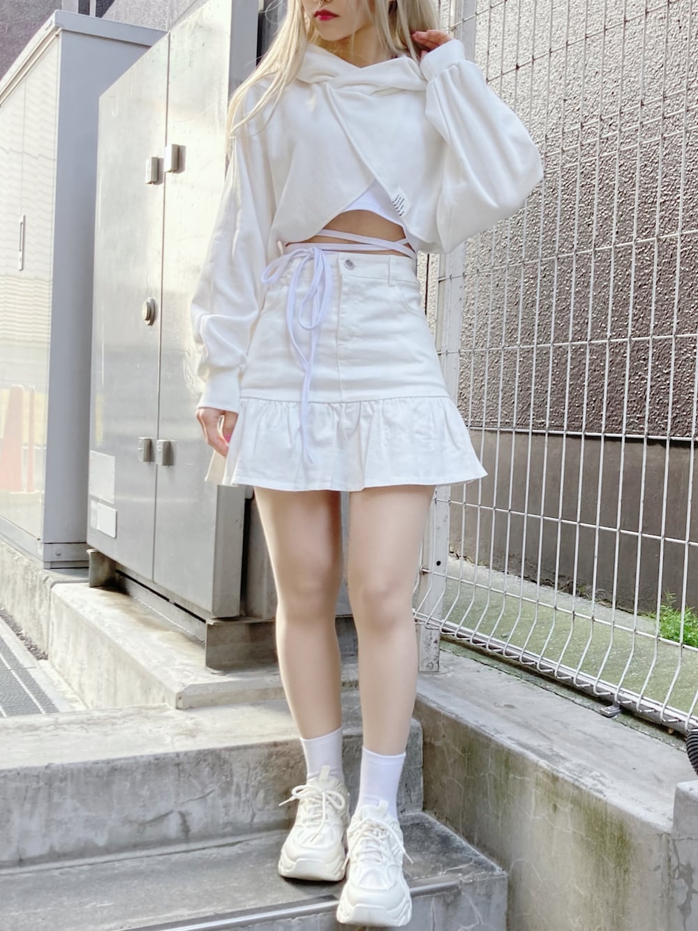 ホワイト系のパーカー、ホワイト系のキャミソール、ホワイト系のスカートを着用したレディースの春コーディネートの1枚目の写真