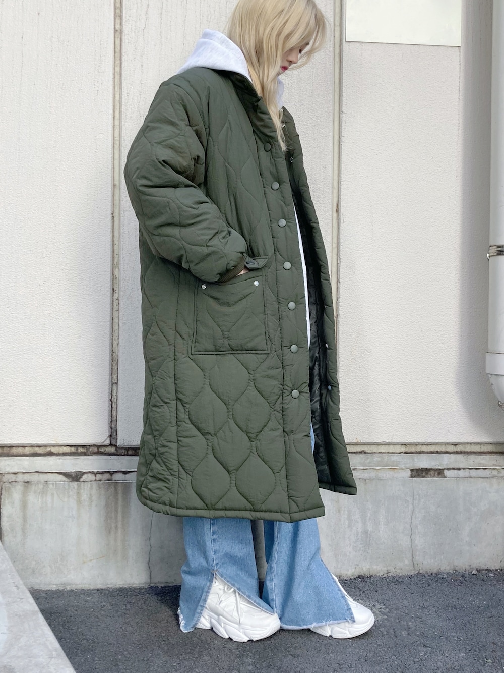 グリーン系のダウンジャケット/コート、ブルー系のデニムパンツ、ホワイト系のスニーカーを着用したレディースの冬コーディネートの1枚目の写真