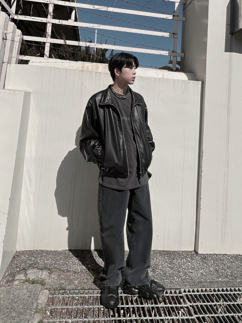 ブラック系のデニムパンツ、ブラック系のブルゾン、グレー系のTシャツ/カットソーを着用したメンズの春コーディネートの1枚目の写真