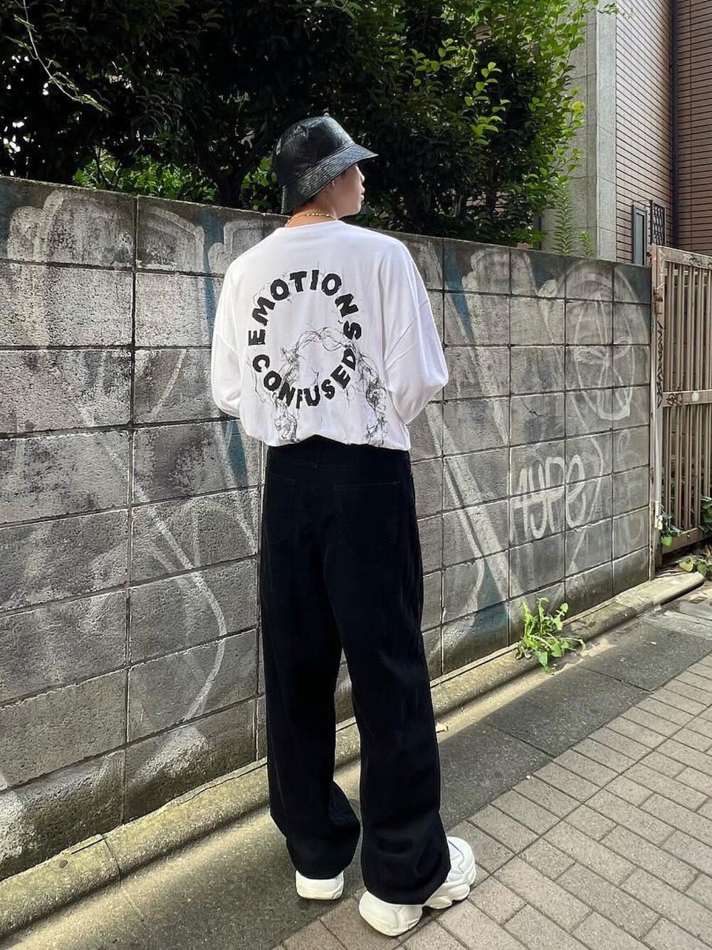 ホワイト系のTシャツ/カットソー、ブラック系のその他パンツ、ホワイト系のスニーカーを着用したメンズの秋コーディネートの1枚目の写真