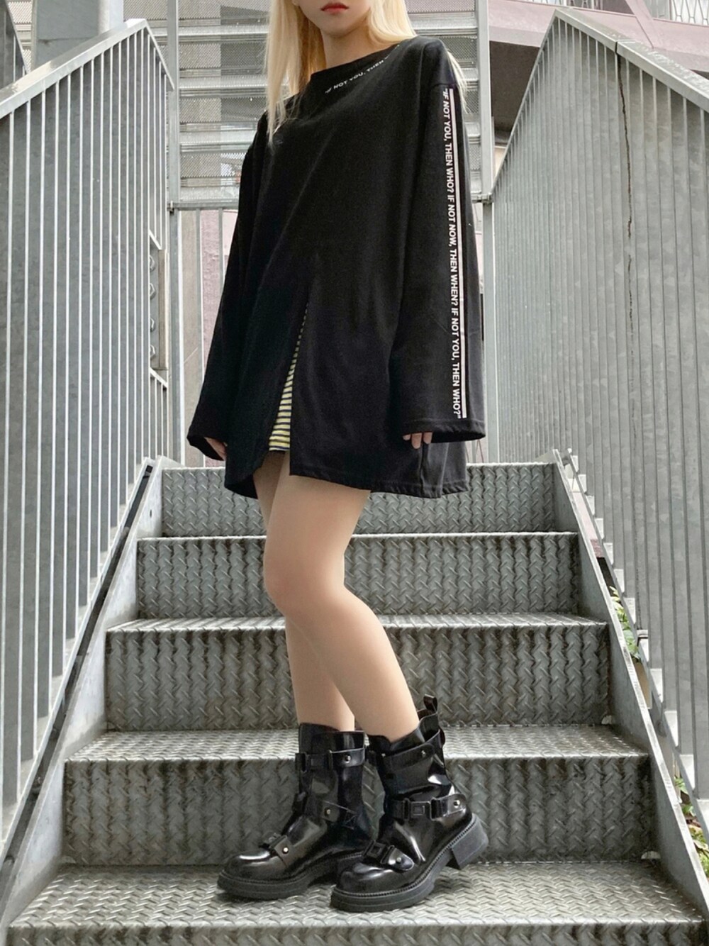 イエロー系のTシャツ/カットソー、ブラック系のTシャツ/カットソー、ブラック系のブーツを着用したレディースの秋コーディネートの1枚目の写真