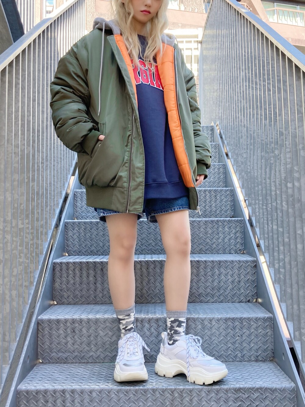 グリーン系のMA-1、ブルー系のデニムパンツ、ホワイト系のスニーカーを着用したレディースの冬コーディネートの1枚目の写真