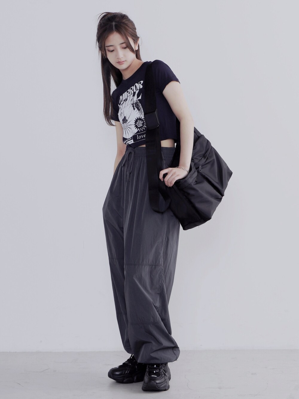 ブラック系のショルダーバッグ、ブラック系のその他パンツ、ブラック系のスニーカーを着用したレディースの夏コーディネートの1枚目の写真