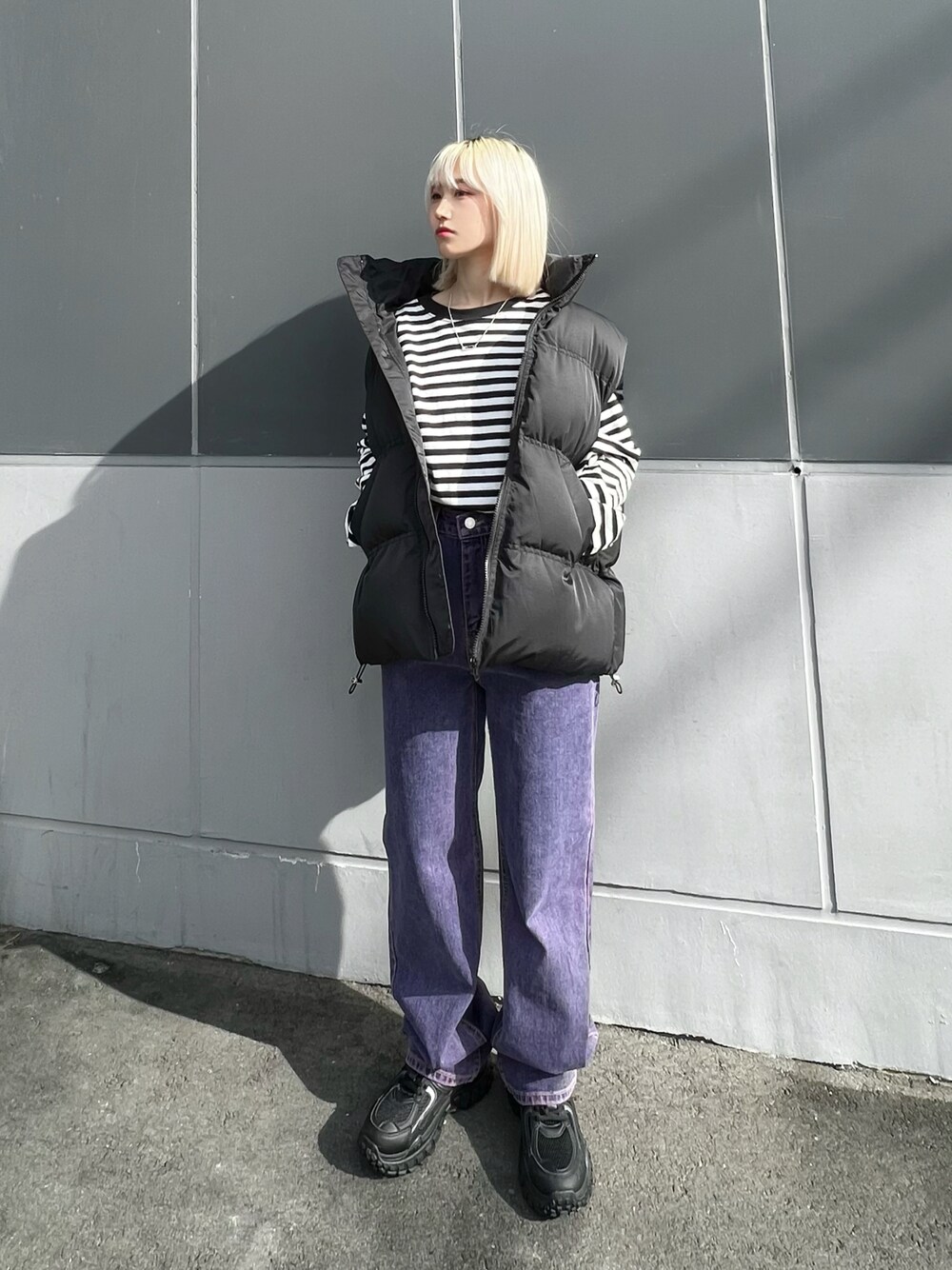 ホワイト系のTシャツ/カットソー、ブラック系のダウンベスト、ブラック系のスニーカーを着用したレディースの冬コーディネートの1枚目の写真