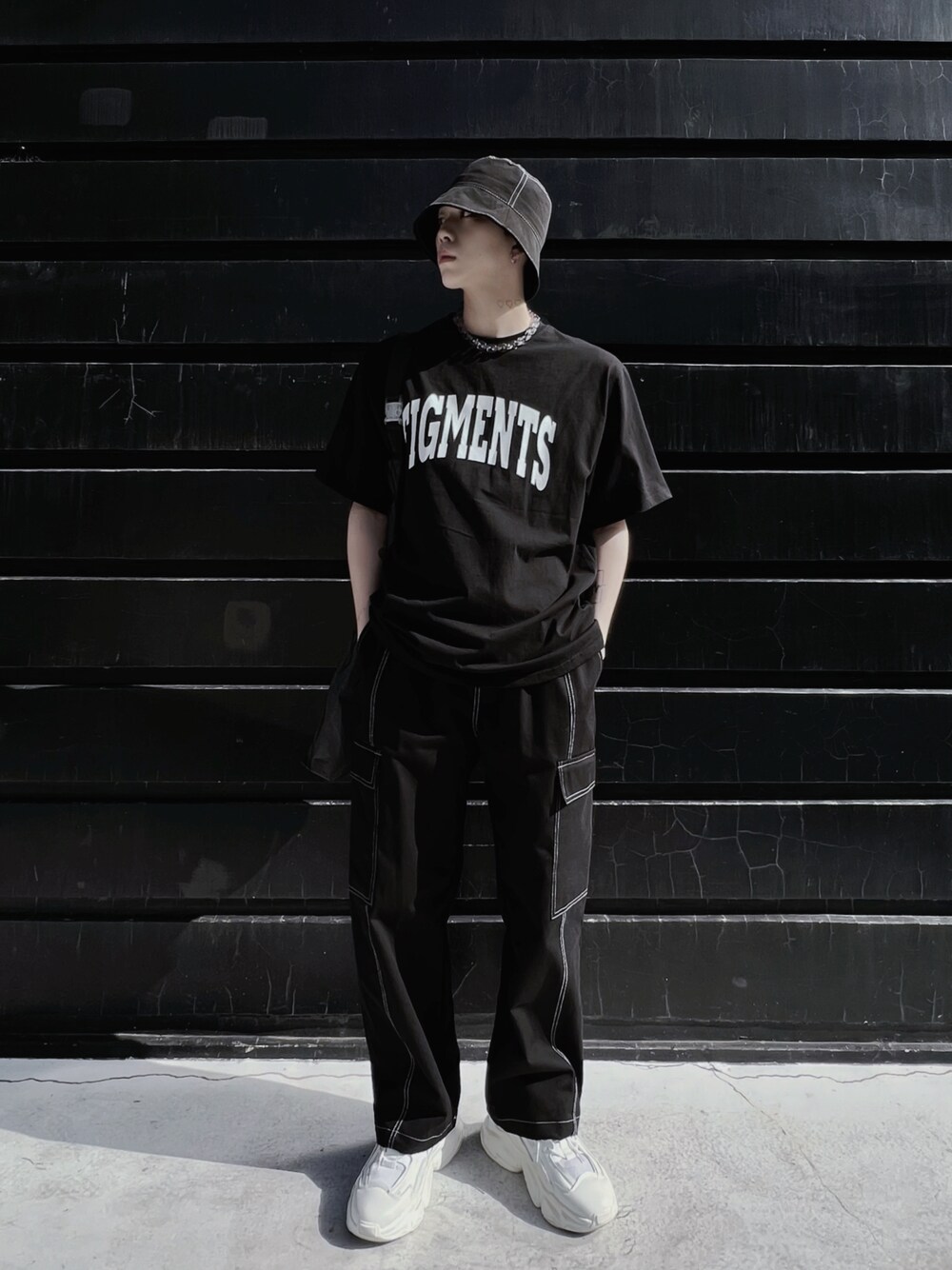 ブラック系のTシャツ/カットソー、ブラック系のトートバッグ、ホワイト系のスニーカーを着用したメンズの春コーディネートの1枚目の写真