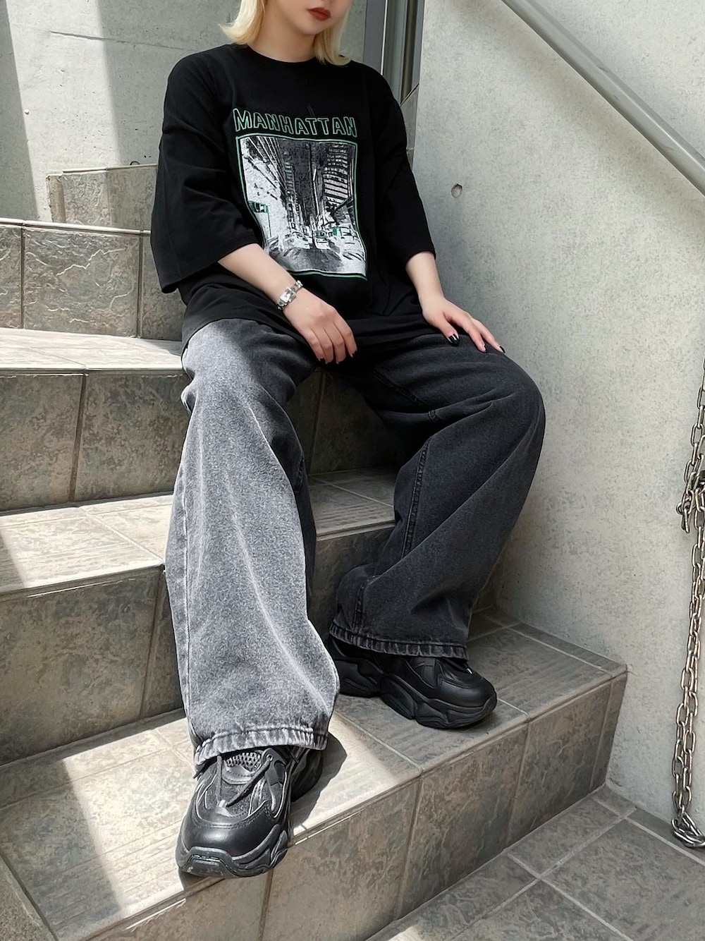 ブラック系のデニムパンツ、ブラック系のスニーカー、ブラック系のTシャツ/カットソーを着用したレディースの夏コーディネートの1枚目の写真