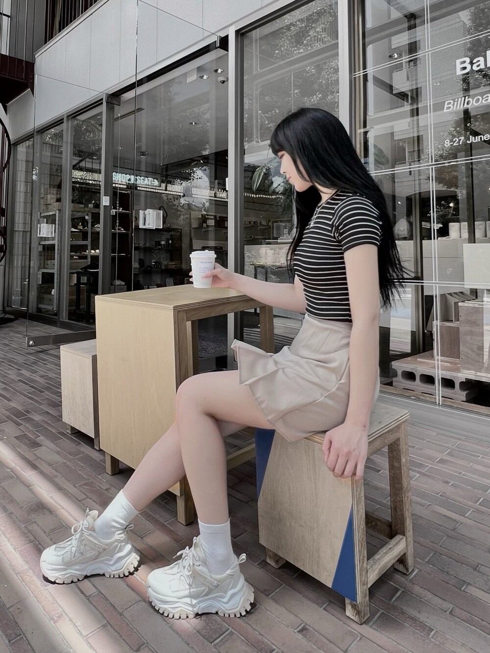 ベージュ系のスカート、ブラック系のTシャツ/カットソー、シルバー系のネックレスを着用したレディースの夏コーディネートの1枚目の写真