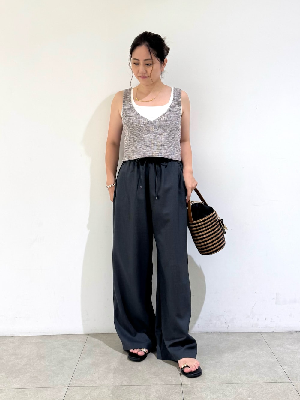 ピンク系のベスト、ホワイト系のタンクトップ、グレー系のその他パンツを着用したレディースの夏コーディネートの1枚目の写真