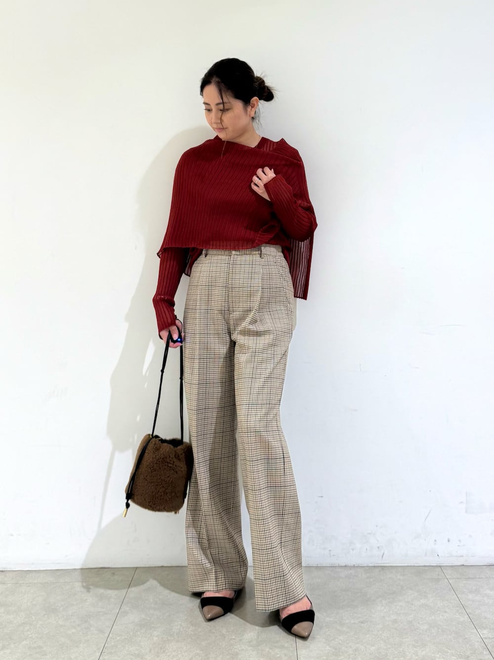 ブラウン系のショルダーバッグ、ブラウン系のパンツ、オレンジ系のニット/セーターを着用したレディースの秋コーディネートの1枚目の写真