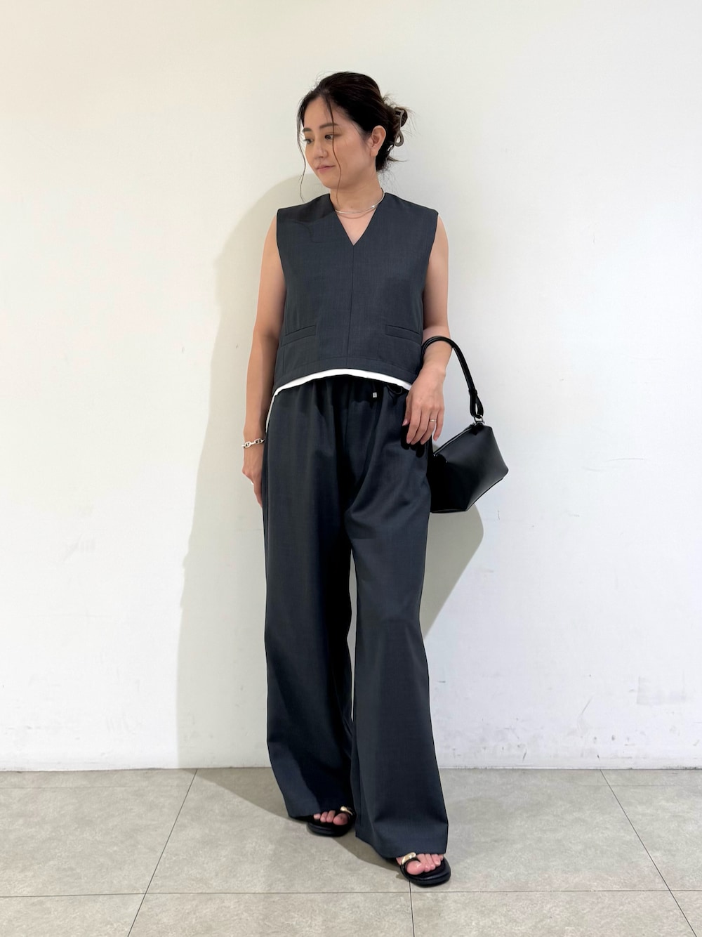 グレー系のタンクトップ、グレー系のその他パンツ、ブラック系のバッグを着用したレディースの夏コーディネートの1枚目の写真