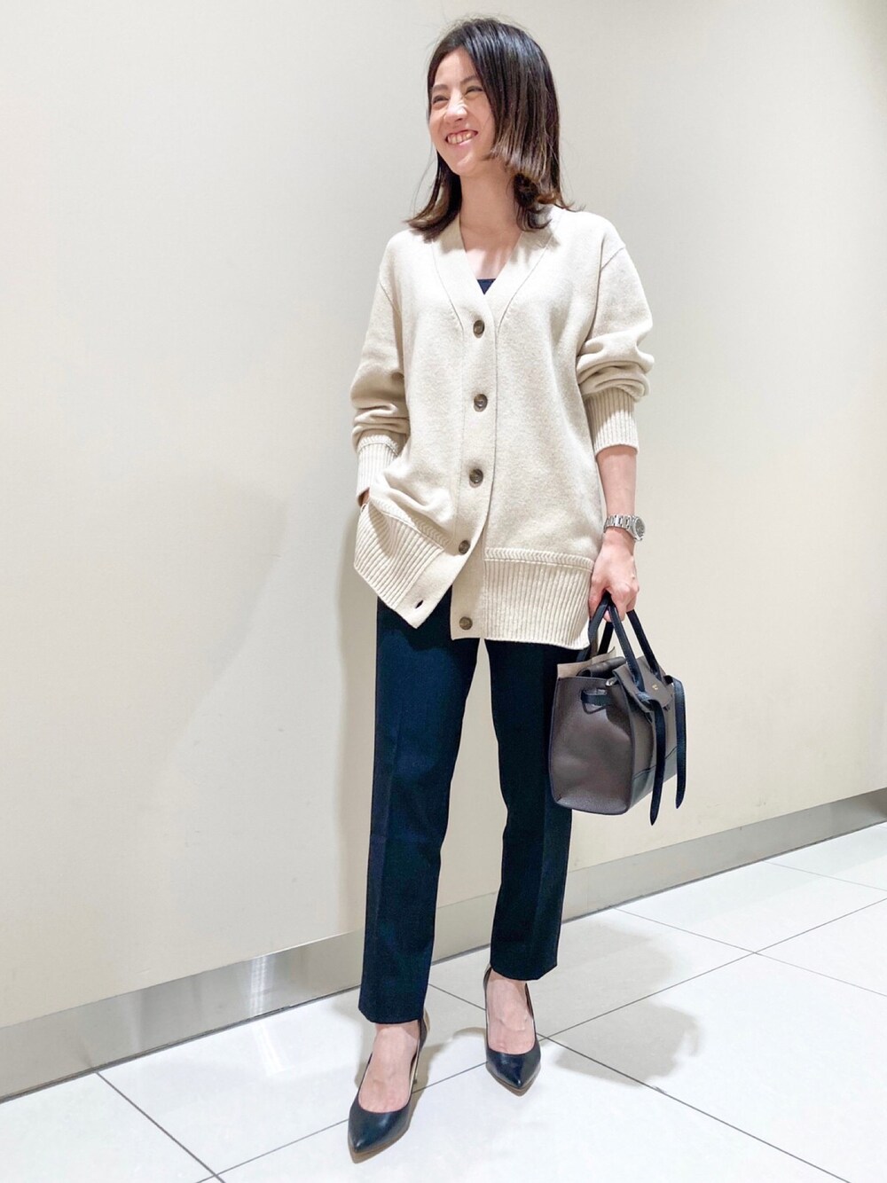 ベージュ系のカーディガン/ボレロ、ブラック系のその他パンツ、ブラウン系のトートバッグを着用したレディースの冬コーディネートの1枚目の写真