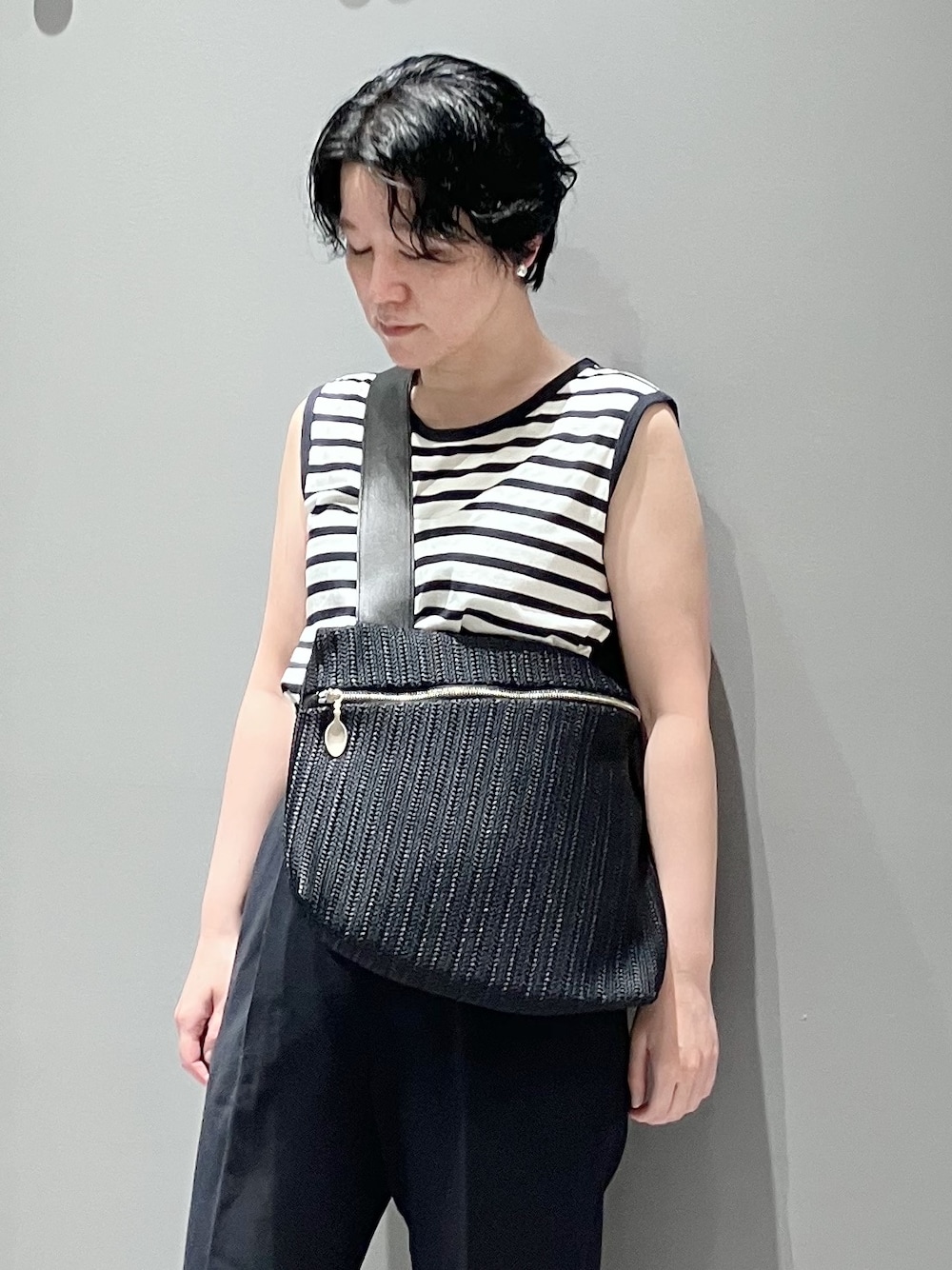 ブルー系のショルダーバッグを着用したレディースの夏コーディネートの1枚目の写真