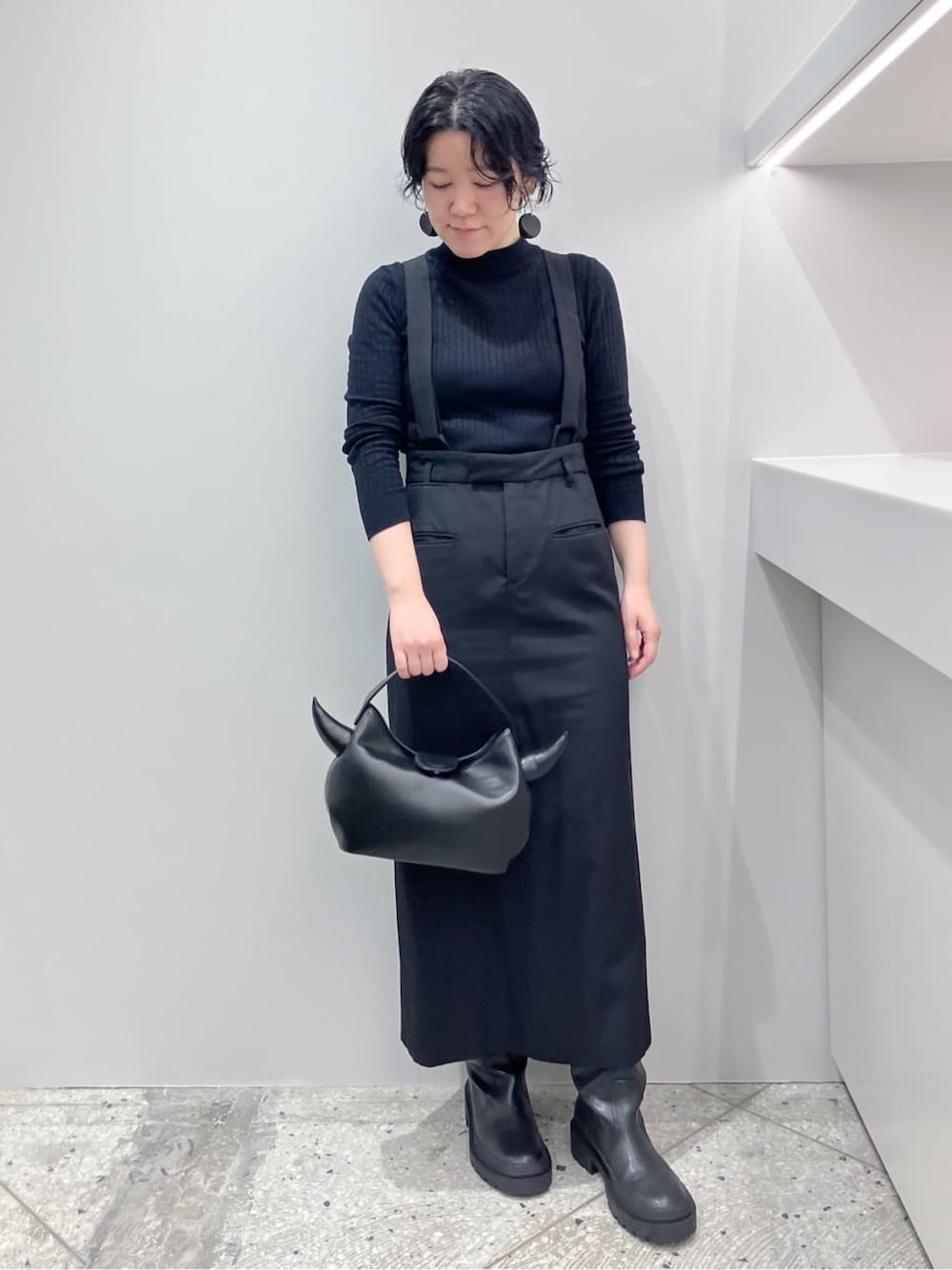 ブラック系のハンドバッグを着用したレディースの秋コーディネートの1枚目の写真