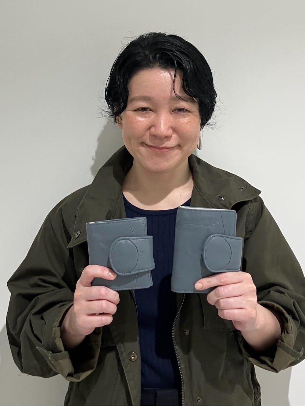 ブラック系の財布、ブルー系の財布、ブルー系の財布を着用したレディースの秋コーディネートの1枚目の写真