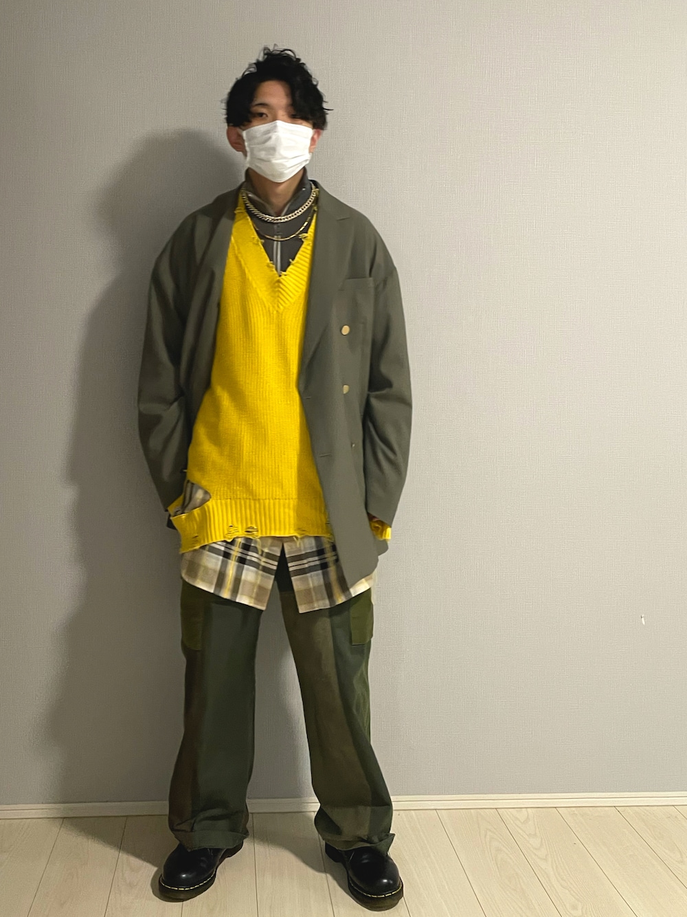 ブラック系のシューズ、グリーン系のカーゴパンツ、イエロー系のニット/セーターを着用したメンズの冬コーディネートの1枚目の写真