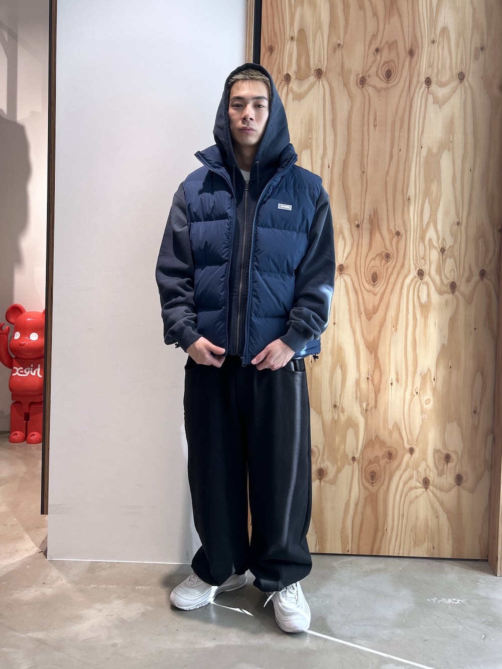 ブルー系のパーカー、ブルー系のベスト、ブラック系のスウェットパンツを着用したメンズの冬コーディネートの1枚目の写真