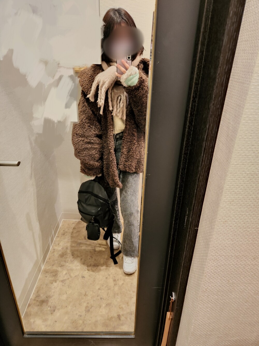 ホワイト系のニット/セーター、ブラウン系のその他アウター、ブラック系のデニムパンツを着用したレディースの冬コーディネートの1枚目の写真