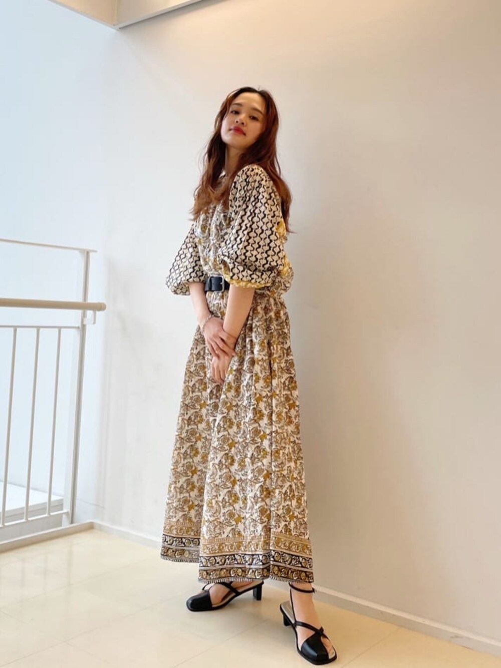 ホワイト系のワンピース、ブラック系のサンダル、ベージュ系のハットを着用したレディースの春コーディネートの1枚目の写真