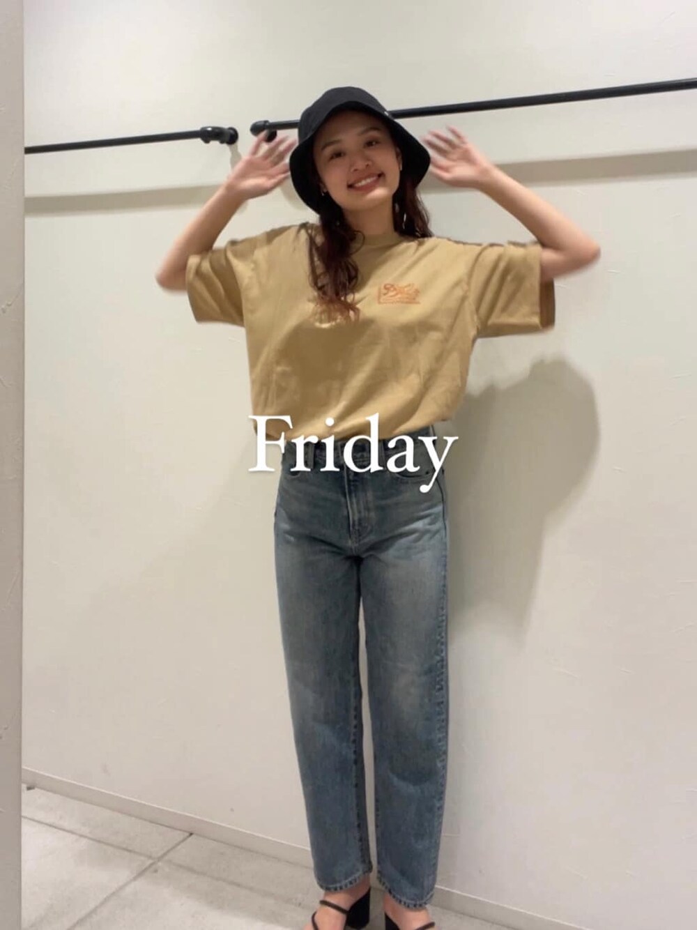 ブルー系のデニムパンツ、ブラック系のサンダル、ベージュ系のTシャツ/カットソーを着用したレディースの夏コーディネートの1枚目の写真