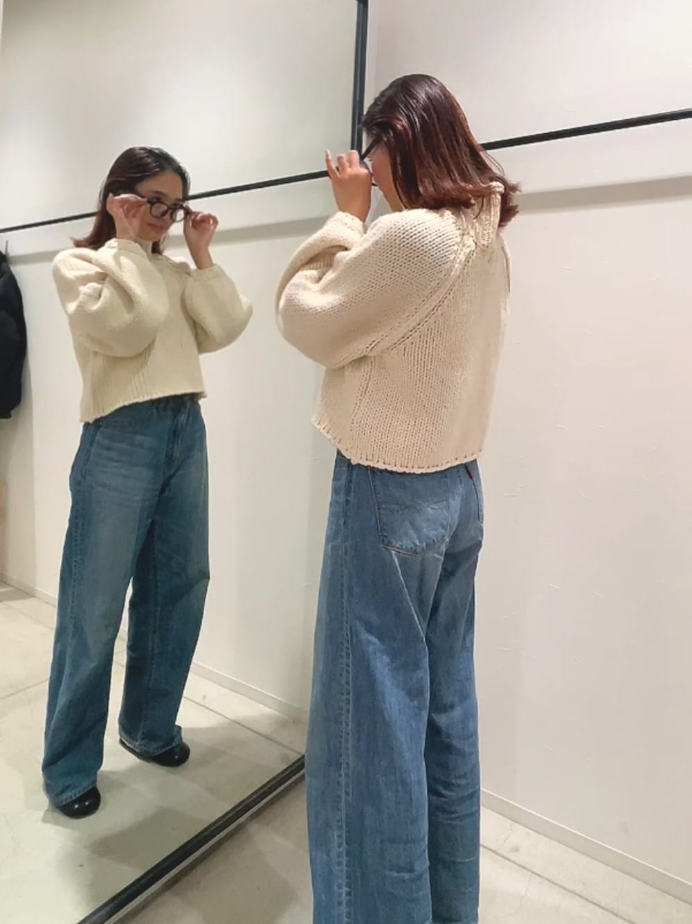 ホワイト系のニット/セーター、ブルー系のデニムパンツを着用したレディースの秋コーディネートの1枚目の写真