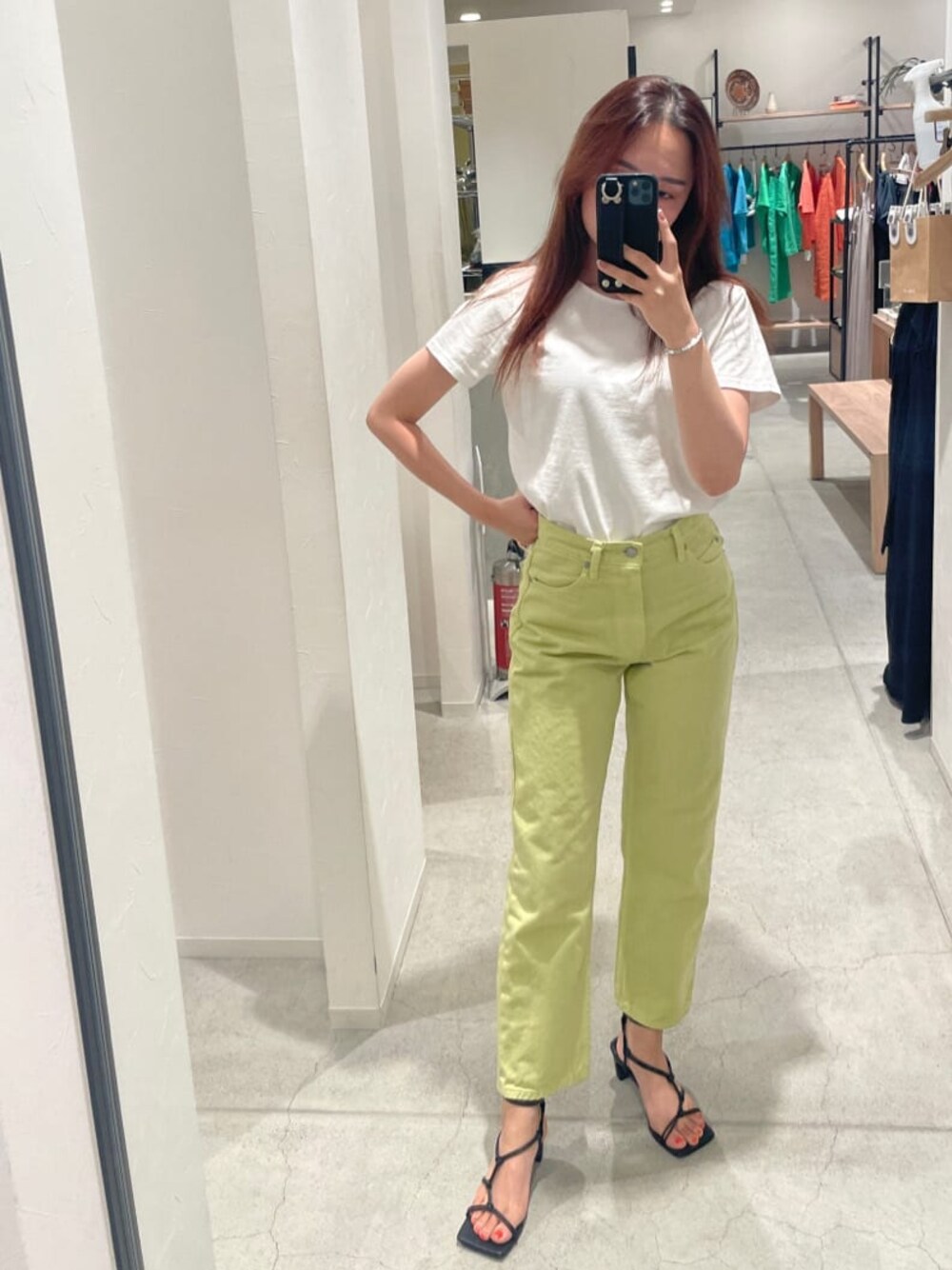グリーン系のデニムパンツ、ホワイト系のTシャツ/カットソー、シルバー系のブレスレットを着用したレディースの春コーディネートの1枚目の写真