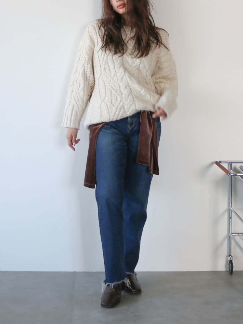 ホワイト系のニット/セーター、ブラウン系のシャツ/ブラウス、ブルー系のデニムパンツを着用したレディースの秋コーディネートの1枚目の写真