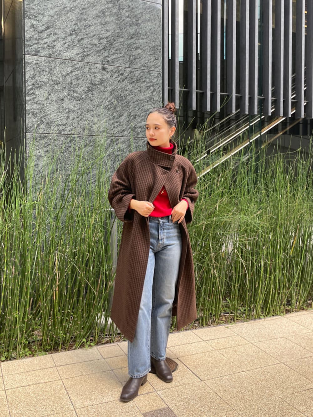 ブルー系のデニムパンツ、ブラウン系のその他アウター、レッド系のニット/セーターを着用したレディースの秋コーディネートの1枚目の写真