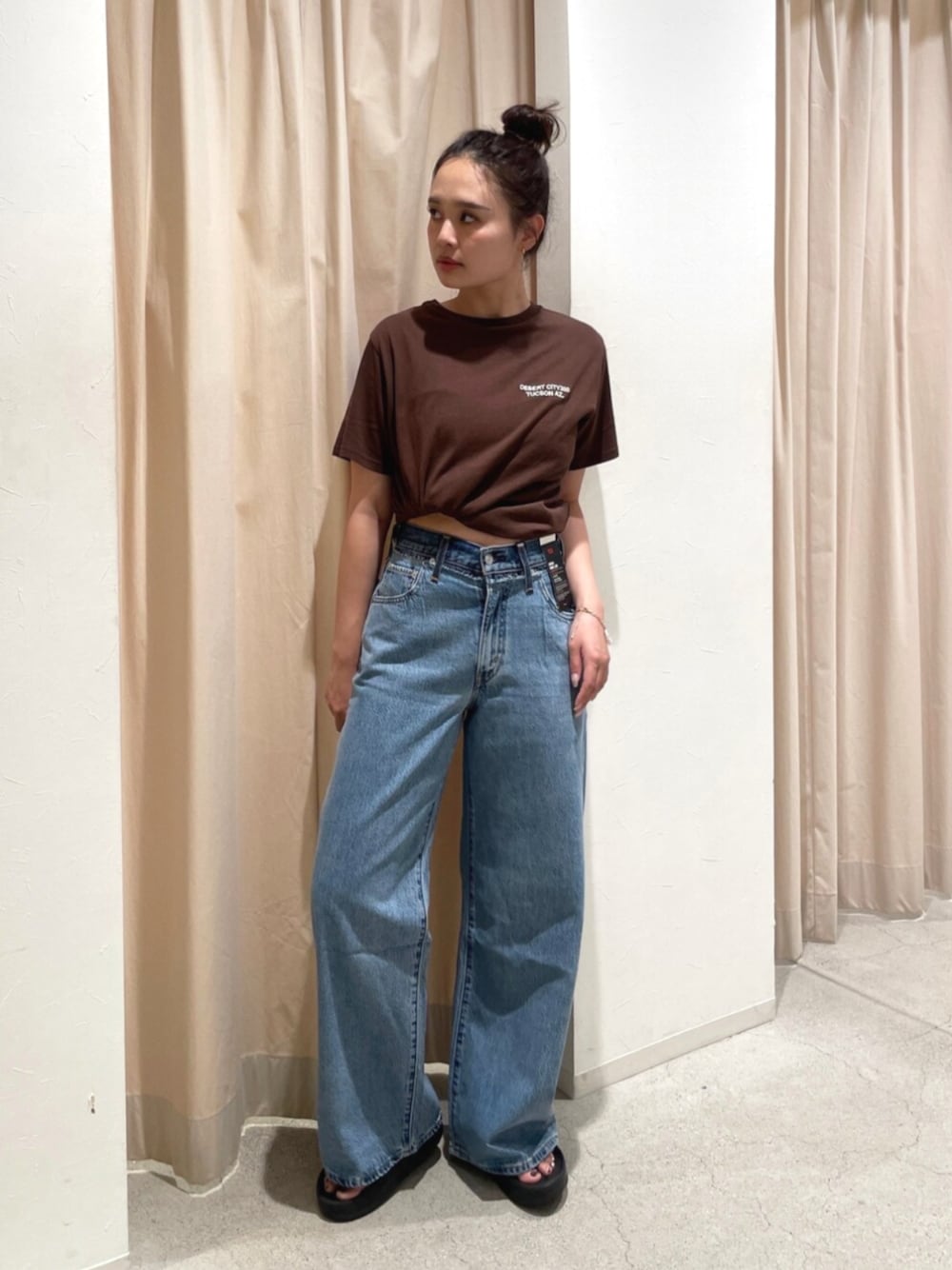 ブルー系のデニムパンツ、ブラウン系のTシャツ/カットソーを着用したレディースの夏コーディネートの1枚目の写真