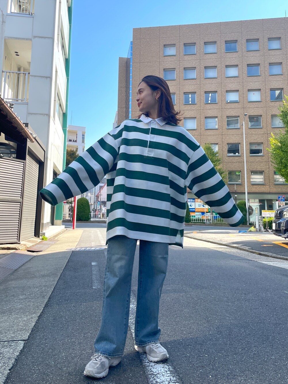 グリーン系のTシャツ/カットソー、ブルー系のデニムパンツを着用したレディースの秋コーディネートの1枚目の写真