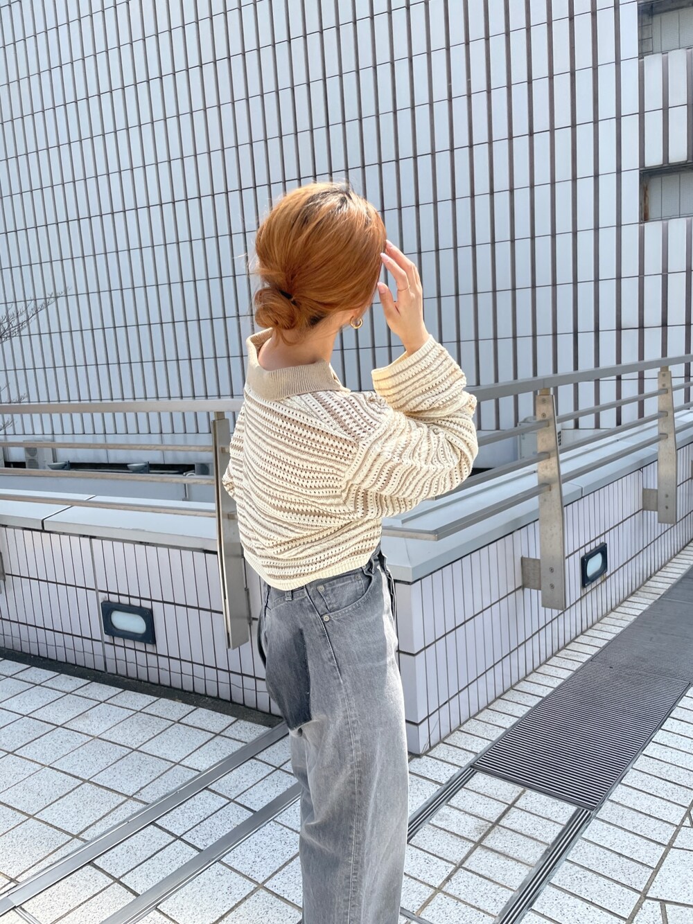 ブラック系のデニムパンツ、ベージュ系のニット/セーターを着用したレディースの春コーディネートの1枚目の写真