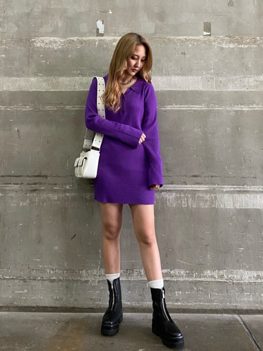 ホワイト系のショルダーバッグ、ブラック系のブーツ、パープル系のワンピースを着用したレディースの冬コーディネートの1枚目の写真