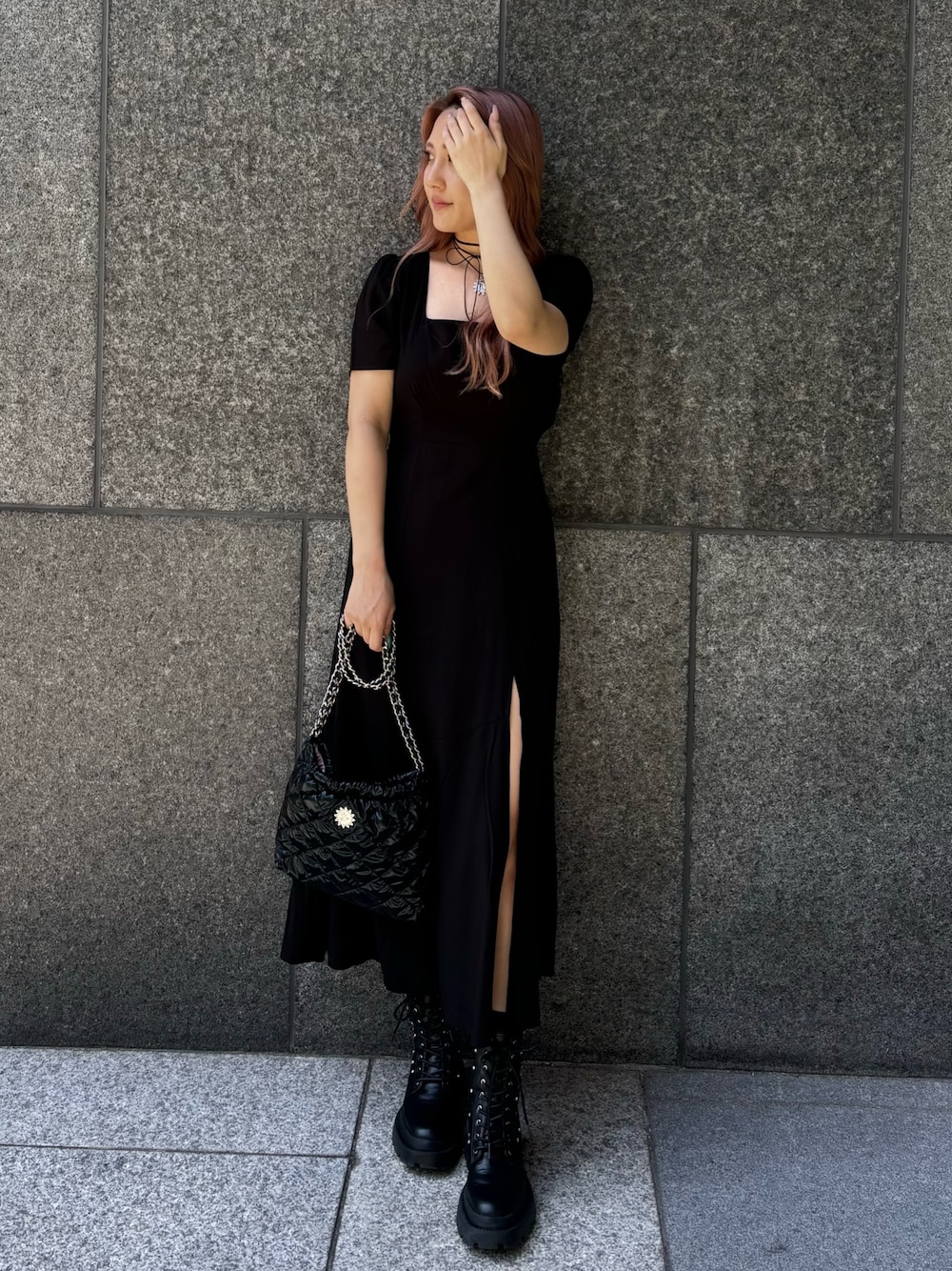 ブラック系のワンピース、ブラック系のショルダーバッグ、ブラック系のブーツを着用したレディースの春コーディネートの1枚目の写真