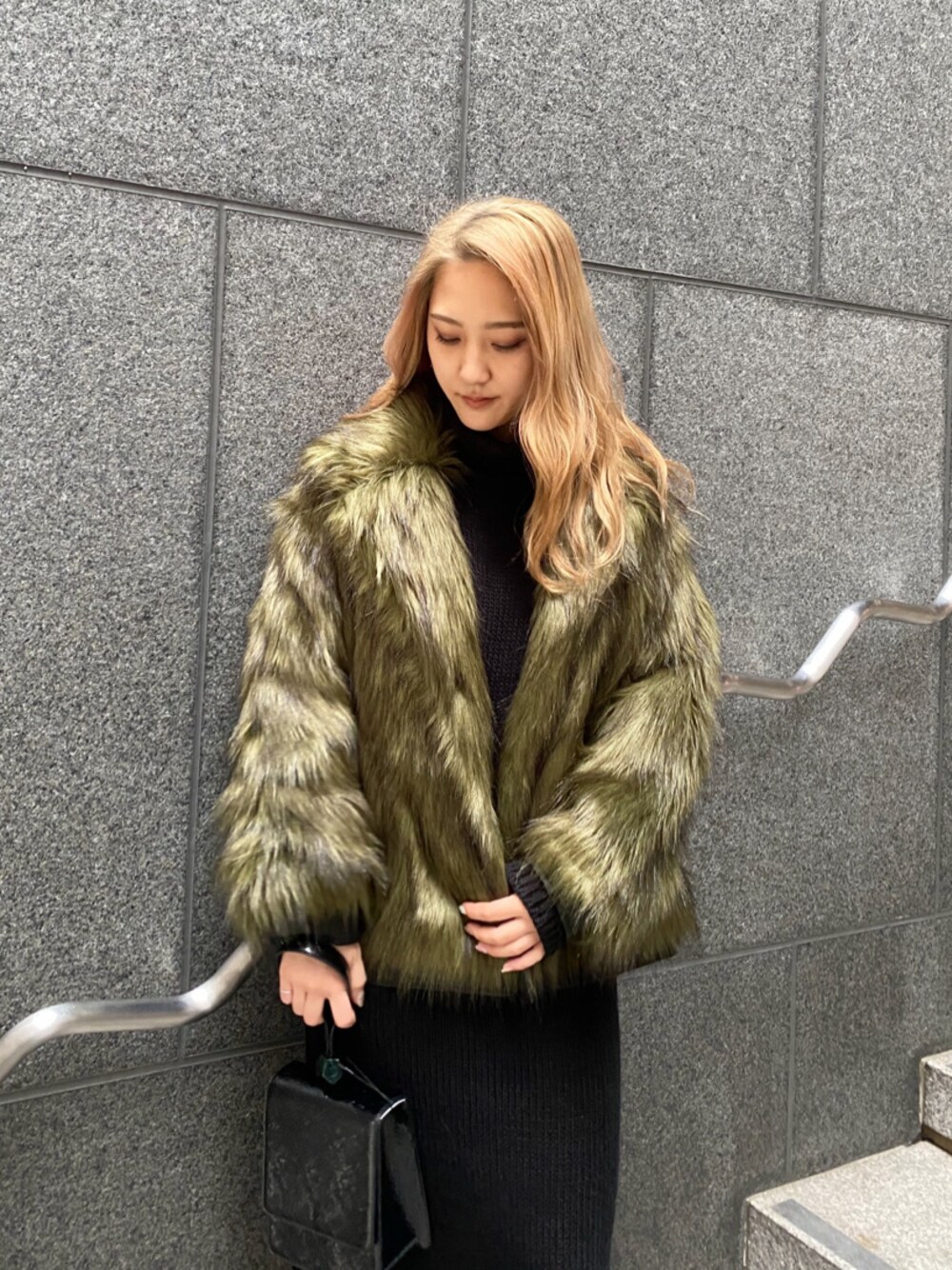 ブラック系のハンドバッグ、ブラック系のワンピースを着用したレディースの冬コーディネートの1枚目の写真