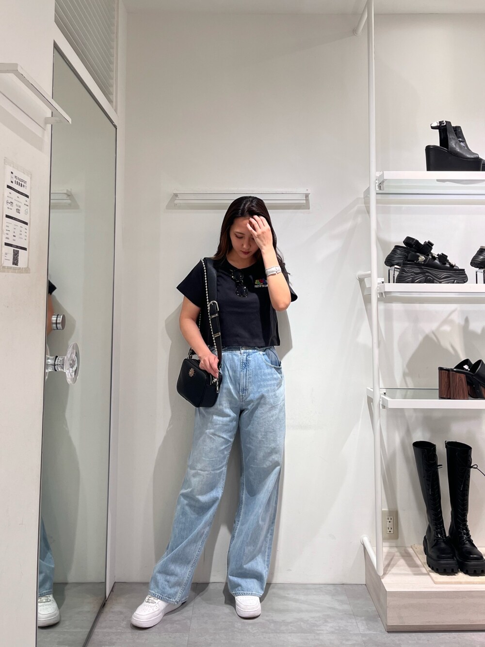ブラック系のTシャツ/カットソー、ブルー系のデニムパンツ、ブラック系のショルダーバッグを着用したレディースの春コーディネートの1枚目の写真