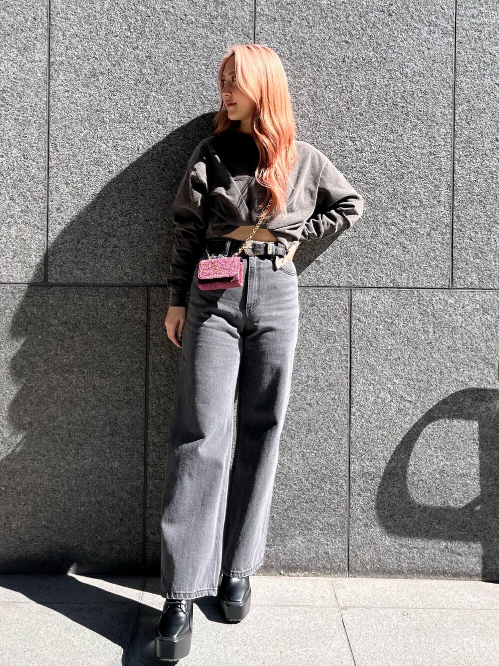 グレー系のTシャツ/カットソー、ブラック系のデニムパンツ、ピンク系のショルダーバッグを着用したレディースの冬コーディネートの1枚目の写真