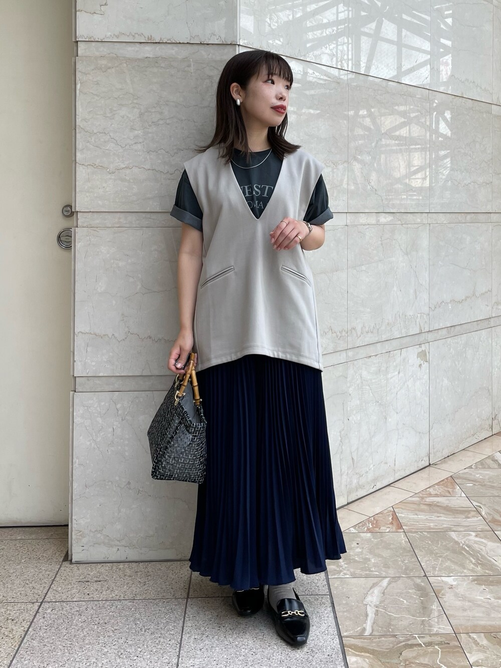 「レイヤードスタイル、きれいめカジュアル、春夏コーデ、モード、休日スタイル、シンプルコーデ、ベスト、Tシャツ、ロゴT、プリーツスカート、ロングスカート、メッシュバッグ、大人カジュアル、お出かけコーデ、スカート」｜「un dix corsのバンブーシアーバッグ（ハンドバッグ、ブラック系）」を使った、まっしーさん（レディース・157cm）の春コーディネートの1枚目の写真